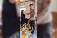 Personil Polsek Tinambung Sedang Membagikan Bantuan Sosial Bagi Warga Tergolong Tidak Mampu.
