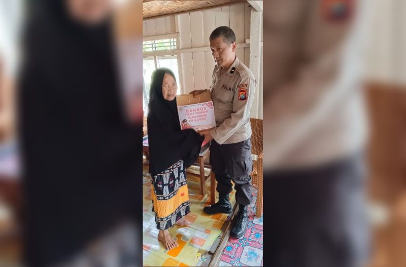 Personil Polsek Tinambung Sedang Membagikan Bantuan Sosial Bagi Warga Tergolong Tidak Mampu.
